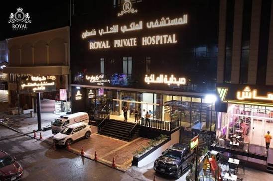 Royal Private Hospital, Palestine Street branch in Baghdad — illuminated facade at night with the hospital pharmacy and ambulance at the entrance.