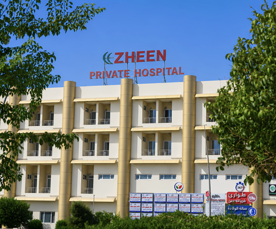 Zheen Private Hospital in Erbil — front facade with the rooftop sign and departmental signboards above the entrance.
