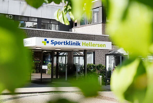 Sportklinik Hellersen in Lüdenscheid, Germany — main entrance of Haus 2 framed by green foliage.