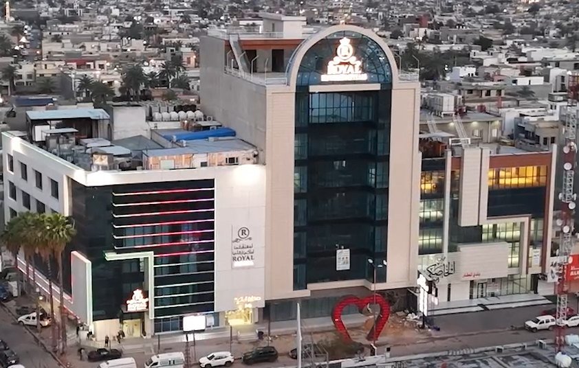 Royal Private Hospital, Palestine Street branch in Baghdad — aerial view of the glass-fronted hospital building at dusk.